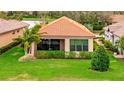 A cozy home with a tiled roof, a screened-in patio, and lush green landscaping at 10213 Saint Francis Ter, Palmetto, FL 34221