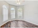 Bedroom with a ceiling fan, hardwood floors, three windows, and lots of natural light at 10810 Moss Island Dr, Riverview, FL 33569