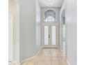 Light and bright foyer with a tiled floor, white walls, and a beautiful glass front door at 10810 Moss Island Dr, Riverview, FL 33569