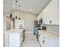 Modern kitchen features white cabinets, stainless steel appliances, and a stylish island with a sink at 122 Jennifer Dr, Rotonda West, FL 33947