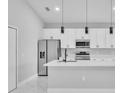 Modern kitchen with sleek stainless steel appliances, white cabinets and a large kitchen island at 122 Jennifer Dr, Rotonda West, FL 33947