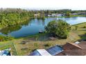 Lakeside backyard featuring lush greenery, a dock, a patio area, and mature trees at 1730 W Del Webb Blvd, Sun City Center, FL 33573