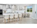 Bright kitchen featuring a large island, stylish pendant lighting, and stainless steel appliances at 17420 Moonflower Dr # 103, Venice, FL 34293
