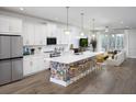 Bright, open kitchen featuring white cabinets, a floral accent island, stainless steel appliances and pendant lighting at 17420 Moonflower Dr # 202, Venice, FL 34293