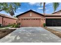 Exterior garage view with well-maintained landscaping and mature palms in a bright and sunny setting at 178 Shell Falls Dr, Apollo Beach, FL 33572