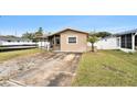 Exterior view of a quaint home featuring a covered porch, small palm tree, and concrete driveway at 1819 Shore Acres Ne Blvd, St Petersburg, FL 33703