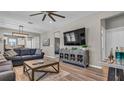 Spacious living room features hardwood floors, a ceiling fan, and a comfortable couch, perfect for relaxation and entertainment at 19437 Ship Wheel Way, Land O Lakes, FL 34638