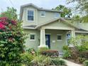 Charming home with a covered porch, blue door, and vibrant flowers in the garden at 208 W Amelia Ave # 1, Tampa, FL 33602