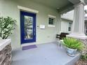 Inviting front porch with a blue door, swing, and potted plants for relaxing outdoors at 208 W Amelia Ave # 1, Tampa, FL 33602