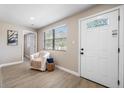 Bright entryway with wood-look flooring, modern decor, and a decorative white front door at 217 Emerald Ln, Largo, FL 33771