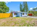 Inviting single-story home with a well-maintained lawn, blue exterior paint, and a freshly painted driveway at 217 Emerald Ln, Largo, FL 33771
