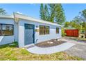 The inviting exterior shows a freshly landscaped yard, a painted walkway, and a well-maintained blue exterior at 217 Emerald Ln, Largo, FL 33771