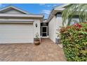 Inviting entryway with brick paving, a well-lit porch, and colorful landscaping at 2222 Mayfield Palms Ln # 322, Sun City Center, FL 33573