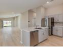 Kitchen island featuring stainless steel dishwasher and sink, opening to the living space at 37233 Sagemoor Dr, Zephyrhills, FL 33541