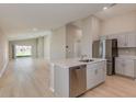 Modern kitchen featuring stainless steel appliances and gray cabinets plus an island with white countertop at 37233 Sagemoor Dr, Zephyrhills, FL 33541