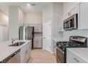 Open kitchen featuring stainless steel appliances, light gray cabinetry, and eat-in counter at 37233 Sagemoor Dr, Zephyrhills, FL 33541