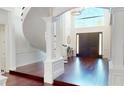 Grand foyer with high ceilings, dark hardwood floors, and a winding staircase at 6413 Maclaurin Dr, Tampa, FL 33647