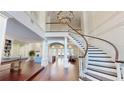 Bright foyer features a winding staircase, chandelier, and hardwood flooring at 6413 Maclaurin Dr, Tampa, FL 33647
