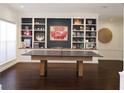 Spacious game room features built-in shelving, hardwood floors, and a ping pong table at 6413 Maclaurin Dr, Tampa, FL 33647