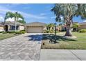 Charming single-story home boasts lush landscaping, a paver driveway, and a two-car garage at 830 Regal Manor Way # 1, Sun City Center, FL 33573