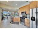 Well-lit kitchen features stainless steel appliances, light wood cabinets, and tile flooring at 830 Regal Manor Way # 1, Sun City Center, FL 33573