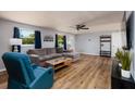 Bright living room with wood-look floors, a comfortable gray sofa, and natural light from the windows at 8871 94Th St, Seminole, FL 33777