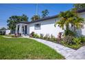 A meticulously landscaped front yard with a stone pathway leading to a beautifully updated white home at 1102 N Albany Ave, Tampa, FL 33607