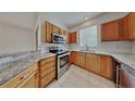 Well-equipped kitchen with stainless steel appliances, granite countertops, and tile flooring at 12426 Country White Cir, Tampa, FL 33635