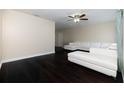 Bright living room featuring dark hardwood floors, a ceiling fan, and a stylish, white sectional sofa at 12605 Catamaran Pl, Tampa, FL 33618