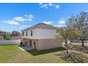 Spacious backyard featuring a well-maintained lawn, a small patio area, and classic two-story architecture at 12802 Lake Vista Dr, Gibsonton, FL 33534