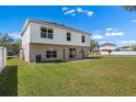 Expansive backyard showing a lush lawn, concrete patio, complemented by a charming two-story house design at 12802 Lake Vista Dr, Gibsonton, FL 33534