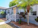 Cozy covered front porch with white railings, complemented by lush landscaping, offering curb appeal at 1528 W River Shore Way, Tampa, FL 33603