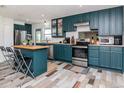 Bright kitchen featuring stainless steel appliances, kitchen island with seating, and stylish blue cabinets at 1528 W River Shore Way, Tampa, FL 33603