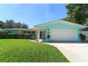 A beautifully landscaped home featuring lush green lawn and colorful flowering bushes at 1922 Oro Ct, Clearwater, FL 33764