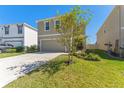 Two-story home showcasing a neutral color scheme, well-kept lawn, and a spacious two-car garage at 30753 Penny Surf Loop, Wesley Chapel, FL 33545