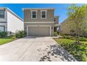 Two-story home showcasing a neutral color scheme, well-kept lawn, and a spacious two-car garage at 30753 Penny Surf Loop, Wesley Chapel, FL 33545