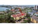 Aerial view shows condo complex in residential area with trees and waterway access at 406 Sandy Hook Rd, Treasure Island, FL 33706
