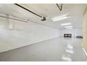 Spacious one-car garage with epoxy flooring, white walls, and ample storage space at 5014 W Lancaster St, Tampa, FL 33616