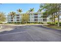 Condo building with a light blue exterior and green roof accents features multiple levels of screened in balconies at 5115 Melbourne St # A303, Port Charlotte, FL 33980