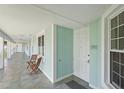 Condo hallway with an entrance door and an open view of a lush green lawn with palm trees at 5115 Melbourne St # A303, Port Charlotte, FL 33980