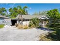 Cozy single-story home with a gravel driveway and mature palm trees adding a touch of tropical charm at 604 5Th Se Ave, Ruskin, FL 33570