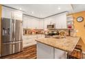 Modern kitchen features white cabinetry, stainless steel appliances, and a granite island at 6262 142Nd N Ave # 904, Clearwater, FL 33760
