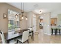 Bright dining area with stylish lighting, a large window, and an open view to the kitchen at 7001 Interbay Blvd # 290, Tampa, FL 33616