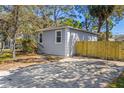 Charming gray home featuring a new, natural wood fence with a spacious driveway at 750 E Harbor S Dr, St Petersburg, FL 33705