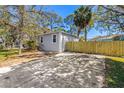 Charming gray home featuring a new, natural wood fence with a spacious driveway at 750 E Harbor S Dr, St Petersburg, FL 33705
