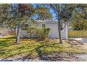 Cozy gray house featuring verdant lawn, shrubs, and a new, natural wood fence at 750 E Harbor S Dr, St Petersburg, FL 33705