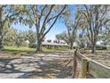 Picturesque view of a home surrounded by mature trees and a rustic wooden fence, offering privacy and tranquility at 808 Old Welcome Rd, Lithia, FL 33547