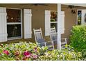 Inviting front porch with rocking chairs and decorative shutters, adding charm to the home's exterior at 808 Old Welcome Rd, Lithia, FL 33547