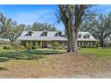 Charming home with a metal roof, dormer windows, and a well-maintained lawn surrounded by mature trees at 808 Old Welcome Rd, Lithia, FL 33547