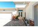 Inviting front entrance with brick pavers, beautifully landscaped, and double doors at 8261 Ivy Stark Blvd, Wesley Chapel, FL 33545